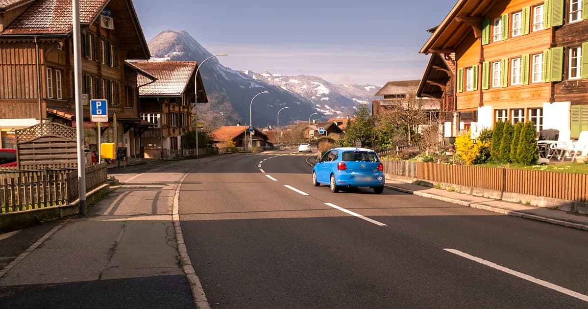 Schweizer Verkehrsregeln auf einer alpinen Strasse mit Verkehrsschildern und Auto
